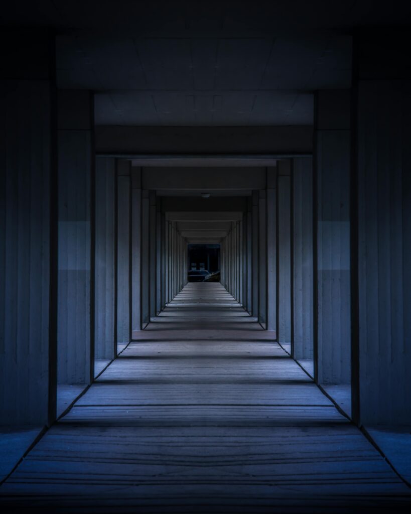 A dramatic view of a modern hallway with symmetrical columns creating an infinite perspective.